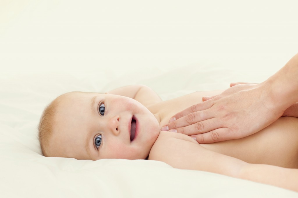 Mother massaging her little baby girl, shallow focus